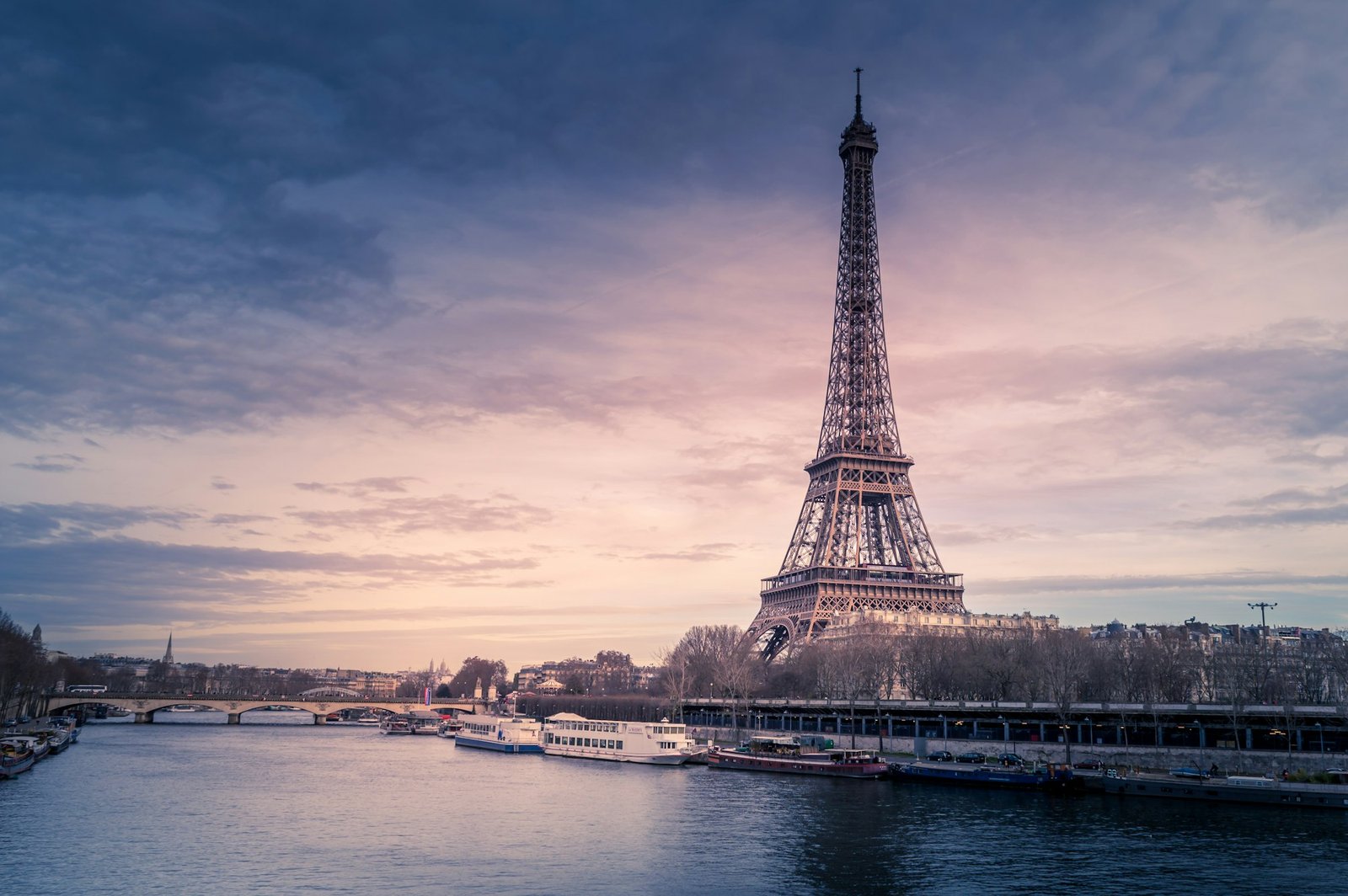 Torre Eiffel ao entardecer, à beira do rio Sena